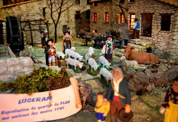 Dans une ruelle de Lucéram, une crèche met en scène des santons dans une ferme