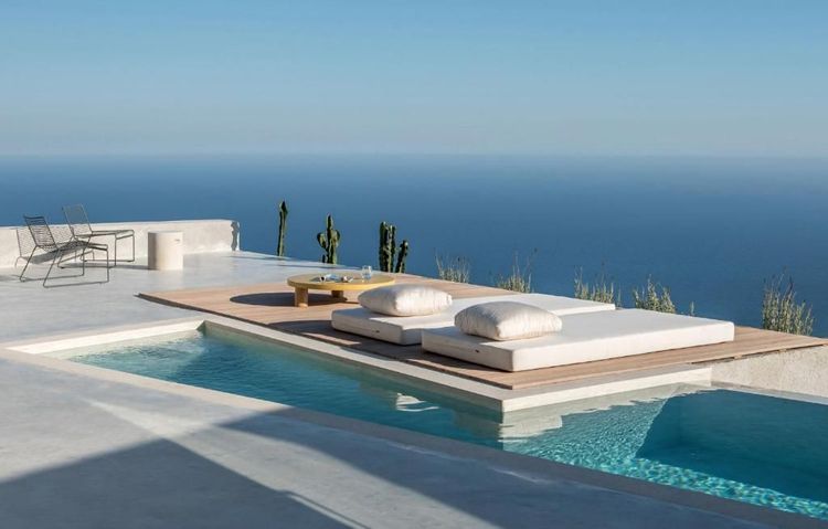 Beds au bord de la piscine de l'hôtel donnant vue sur la mer