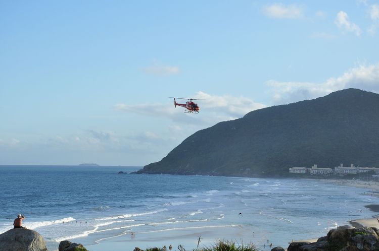 Un hélicoptère survolant la plage de Florianopolis au Brésil