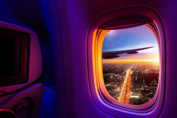 La vue depuis le hublot d'un avion au coucher du soleil