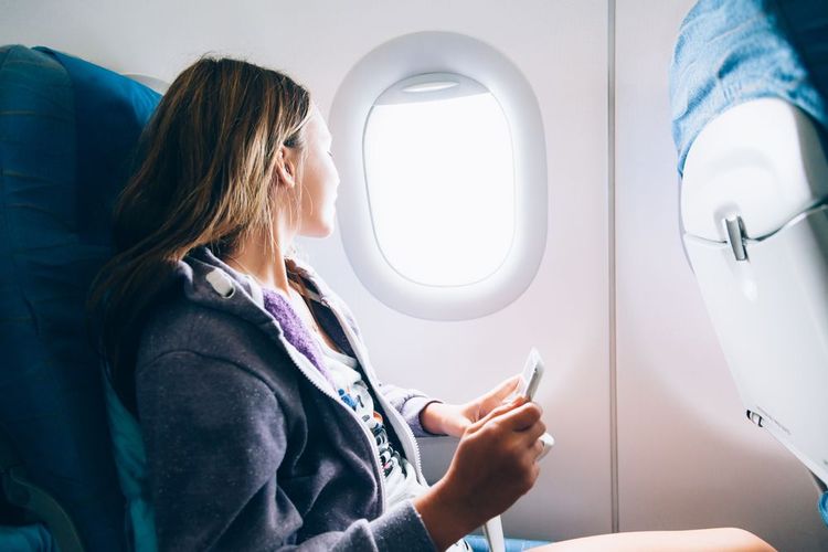 Une passagère profitant de la vue depuis le hublot de l'avion