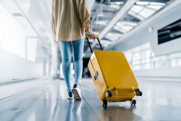 Une touriste dans un aéroport avec sa valise à la main