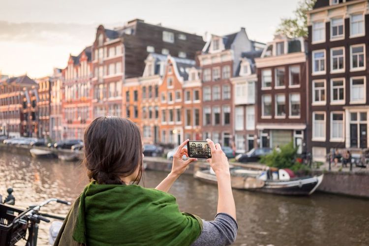 Une touriste photographie les canaux d'Amsterdam
