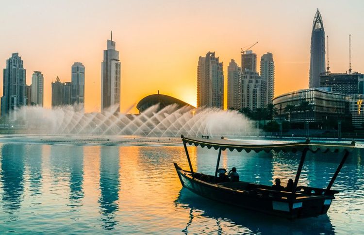 Boutre face aux buildings de Dubaï au coucher du soleil 