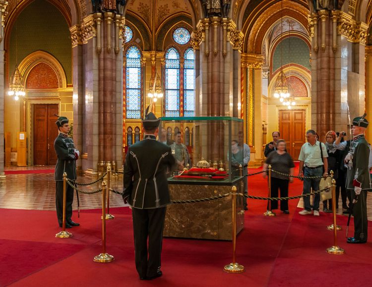 Budapest, Hungary - September 18, 2010: Presentation of the Holy Crown of Hungary to a group of tourists in the central hall of the Hungarian Parliament. Closely guarded by a guard of honor.