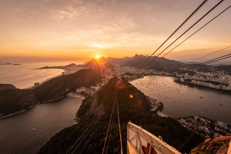 Coucher de soleil doré de la montagne du Pain de sucre au téléphérique, à la ville et à l'océan, à Rio de Janeiro, Brésil