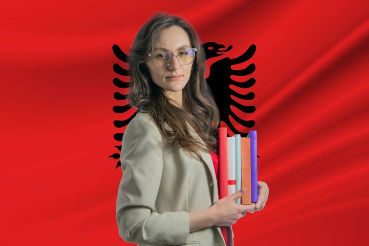 Célébration de la Journée internationale des bibliothécaires devant le drapeau albanais