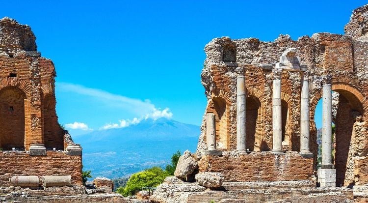 Les colonnes grecques en haut de l'enceinte du théâtre, et l'Etna au loin