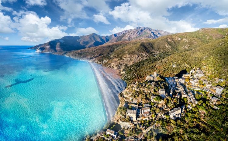 Luftaufnahme mit dem Dorf Nonza und seinem Kieselstrand