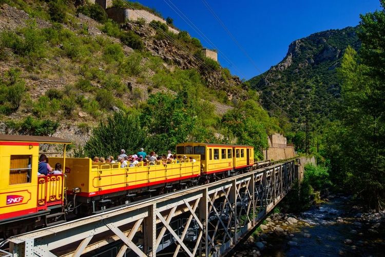 The Little Yellow Train passing through Villefranche-de-Conflent, Pyrénées-Orientales