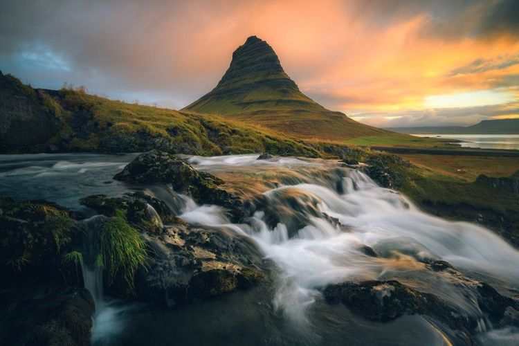 La montagne Kirkjufell avec la rivière au premier plan, en Islande, coucher du soleil
