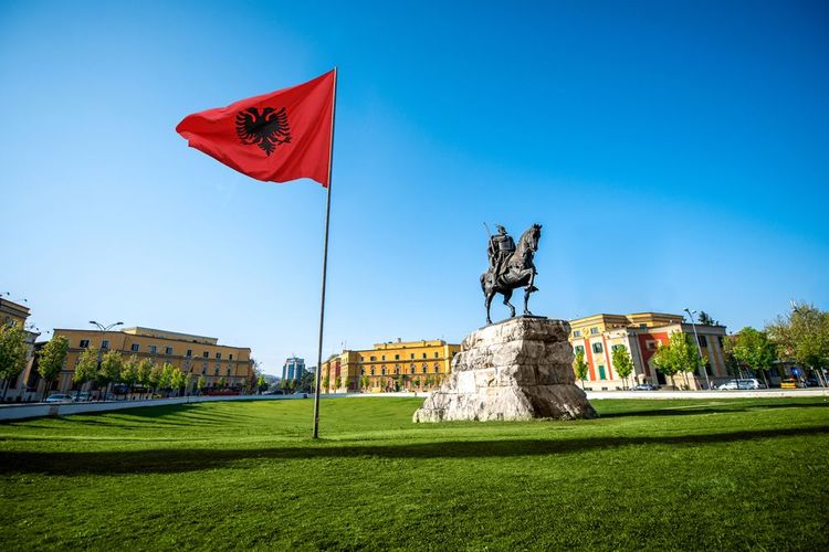 La statue équestre de Skanderbeg sur la plaec homonyme et le drapeau albanais