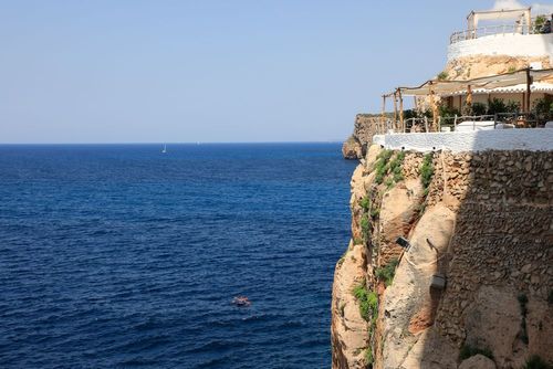 Boire un verre dans une grotte c’est possible ! Ce bar à flan de falaise est le lieu le plus branché de Minorque